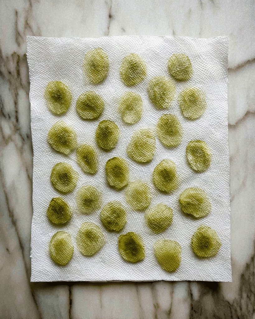 Air fryer fried pickles slices drying on paper towel before coating