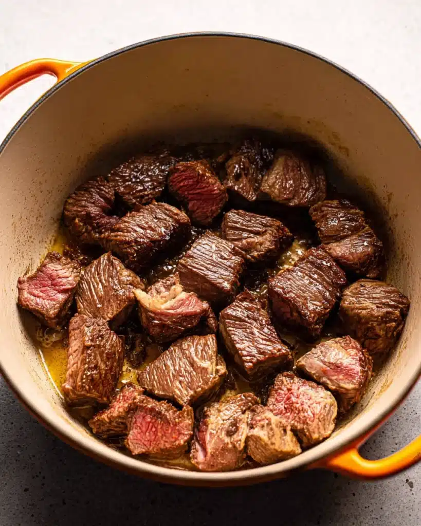 Beef chuck cubes searing in Dutch oven for classic beef bourguignon