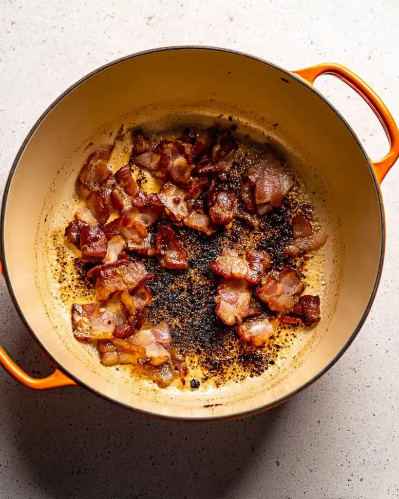 Crispy bacon cooking in Dutch oven for classic beef bourguignon