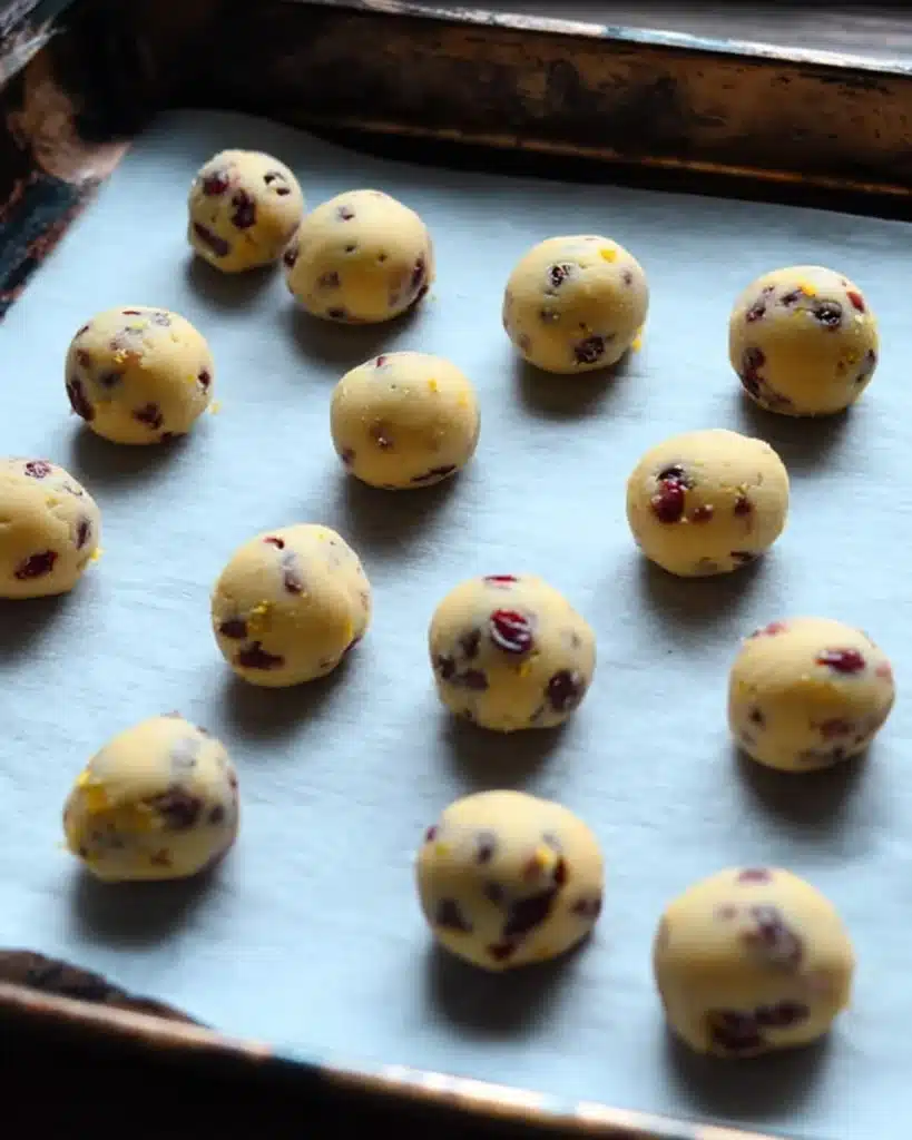 Rolled cranberry orange cookie dough balls on baking tray