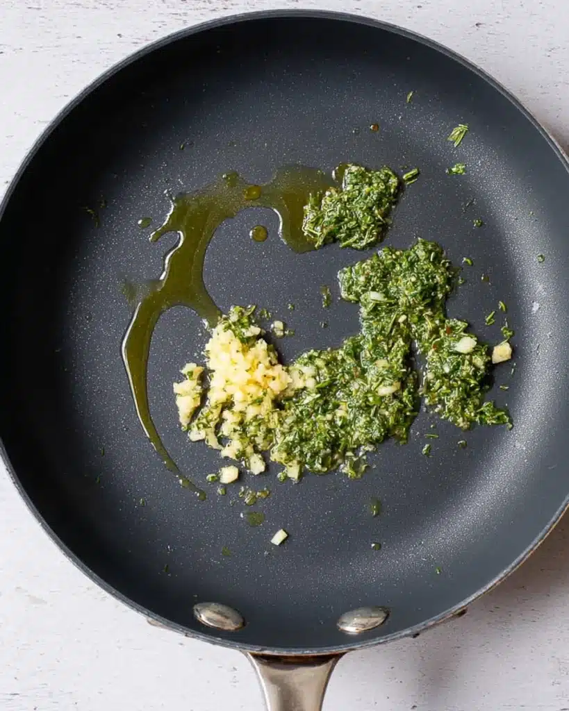 Garlic and sage sautéing in olive oil in a skillet