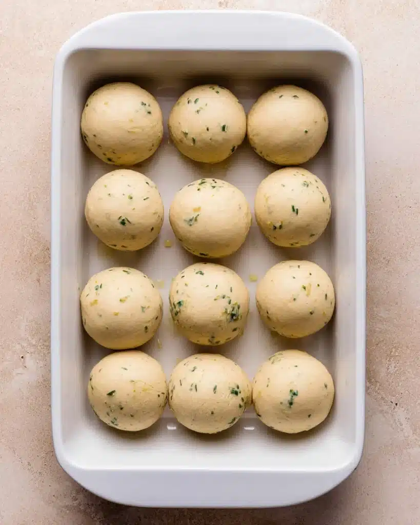 Easy Garlic Bread Rolls (Perfect for Thanksgiving) 4 Shaped dough balls in baking dish for Easy Garlic Bread Rolls