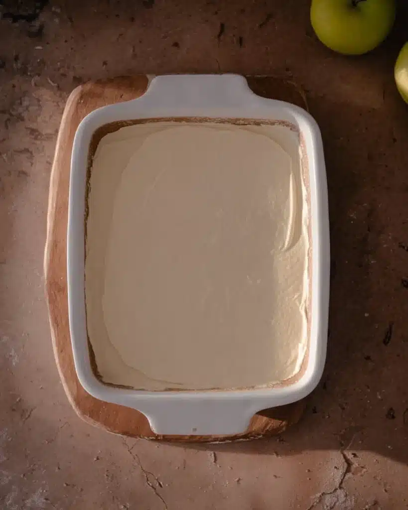 Cheesecake base spread in white dish for easy caramel apple cheesecake dip recipe