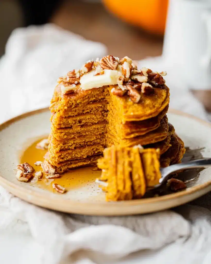 Healthy Pumpkin Pancakes 6 Fluffy healthy pumpkin pancakes cut open with butter and pecans