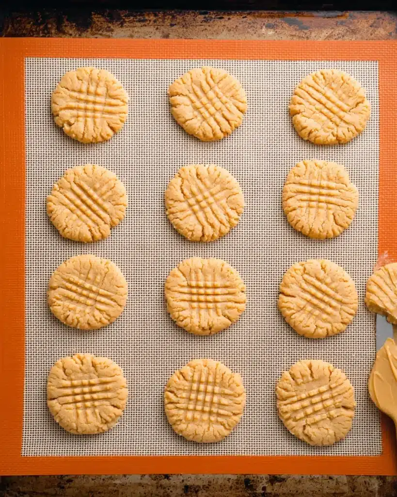 Tray of baked peanut butter cookies with crisscross fork marks
