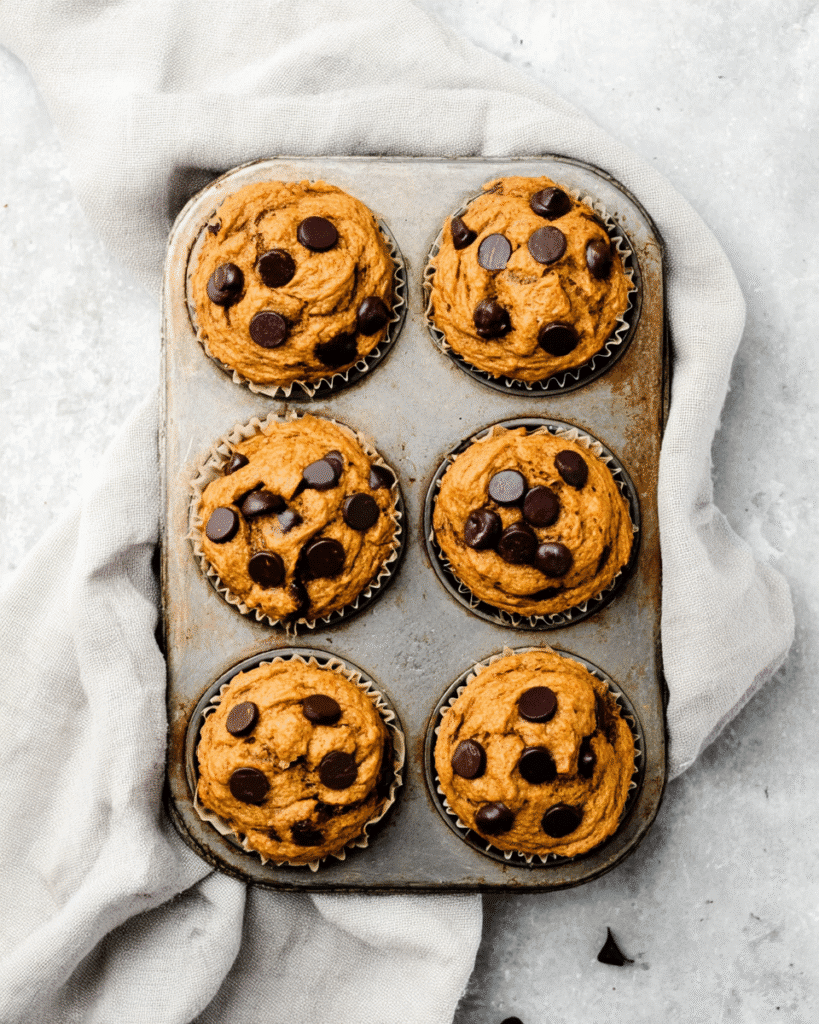 Freshly baked pumpkin chocolate chip protein muffins in muffin tin