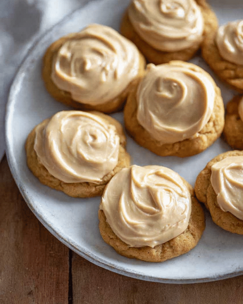 Pumpkin cookies with caramel frosting on a plate, soft and frosted