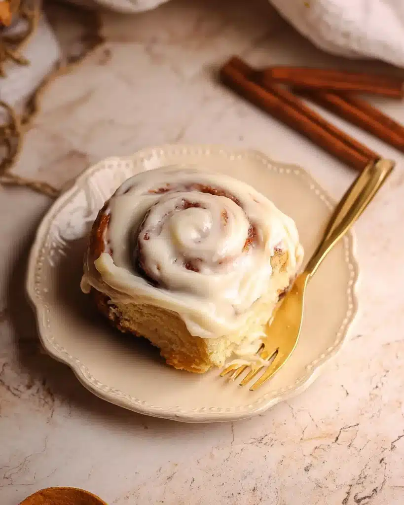 The Best Cinnamon Rolls EVER (Halloween Edition) 1 Frosted cinnamon roll on plate with golden fork