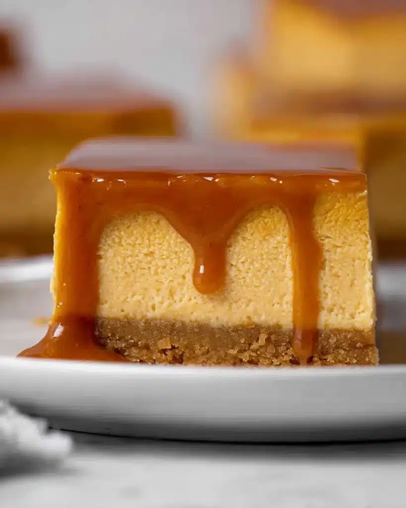 The Best Pumpkin Cheesecake Bars Ever stacked with caramel drizzle