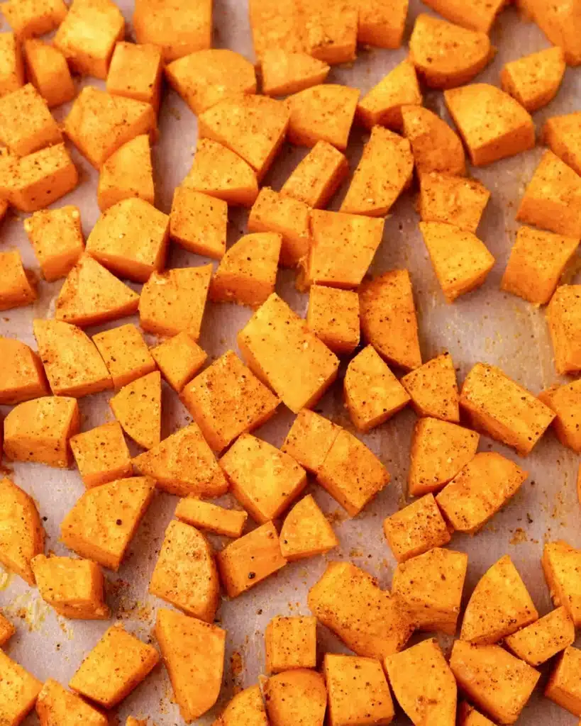 Raw cubed sweet potatoes on parchment paper for Whole30 sloppy joes