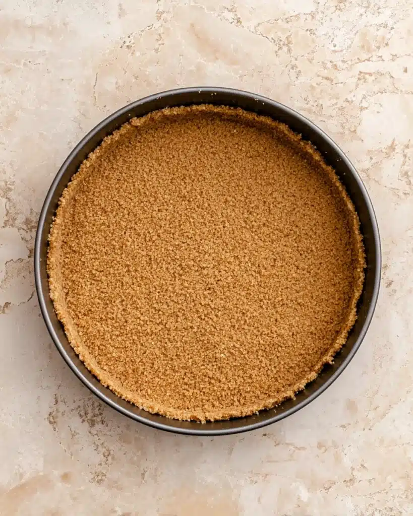 Apple Crumble Cheesecake – The Perfect Thanksgiving Dessert 3 Golden graham cracker crust pressed into springform pan for cheesecake