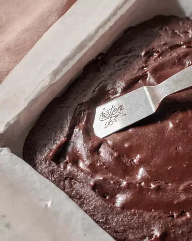 Spreading brownie batter in baking pan with spatula
