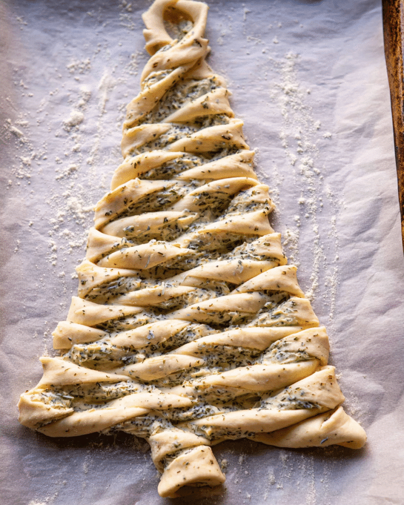 Unbaked twisted dough shaped into a Christmas tree garlic bread