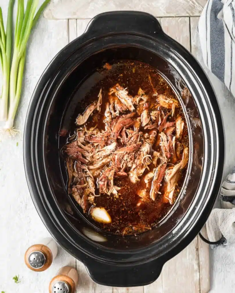 Crock Pot Bourbon Chicken 5 Shredded chicken in bourbon sauce inside slow cooker