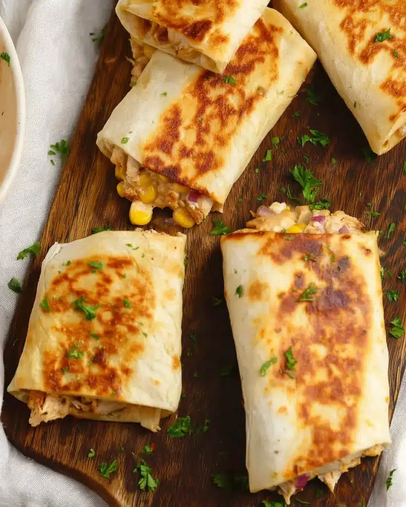 Crispy easy chicken wraps with melted cheese and corn on wooden board