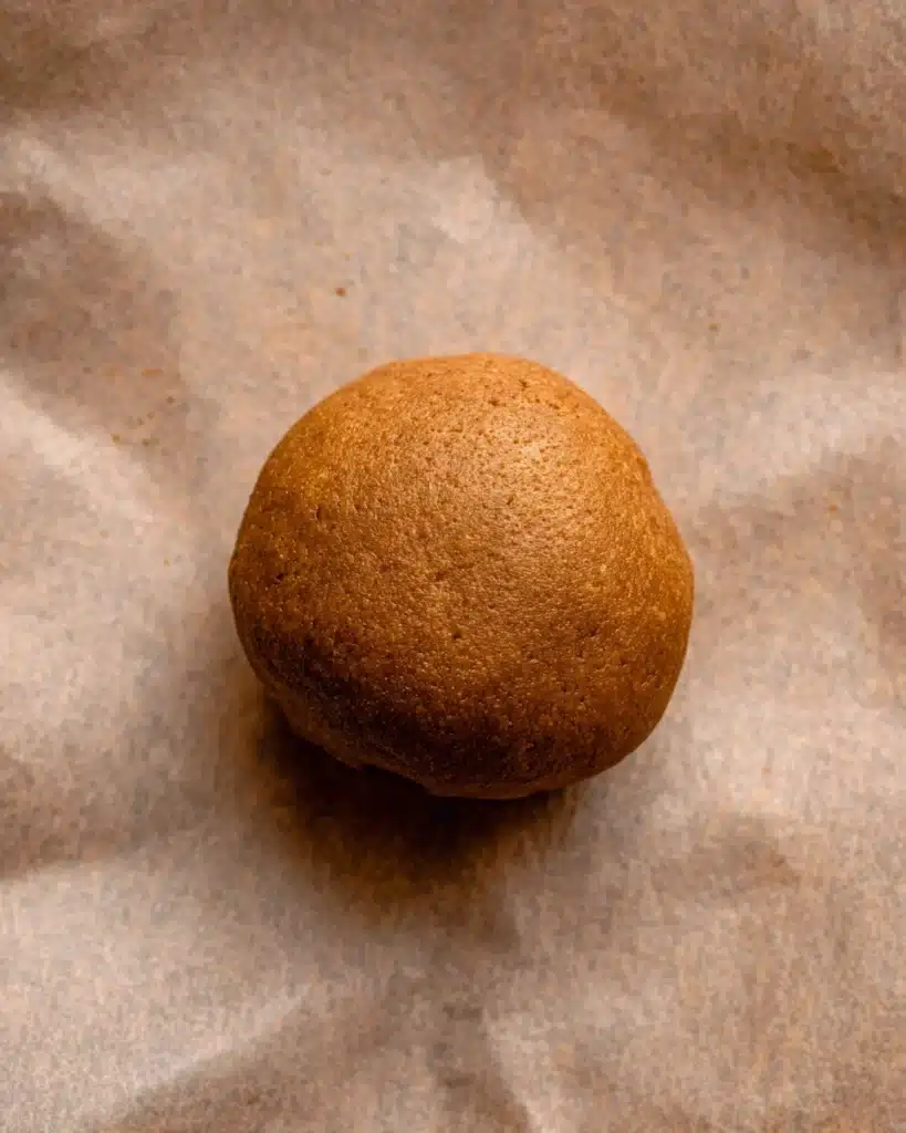 Smooth gingerbread cheesecake cookie dough ball on parchment paper