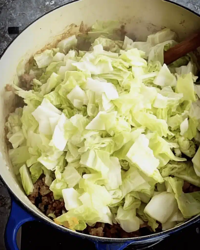 Fresh cabbage added to sausage and onions for Golumpki Soup