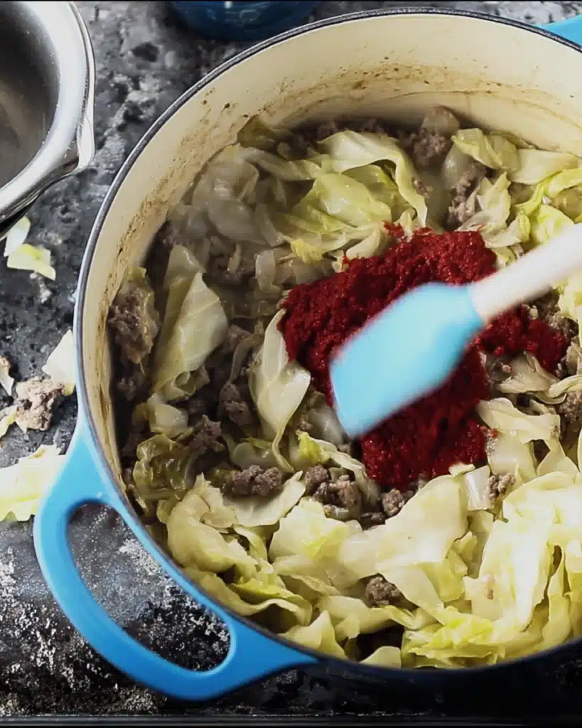 Tomato paste added to cabbage and sausage for Golumpki Soup
