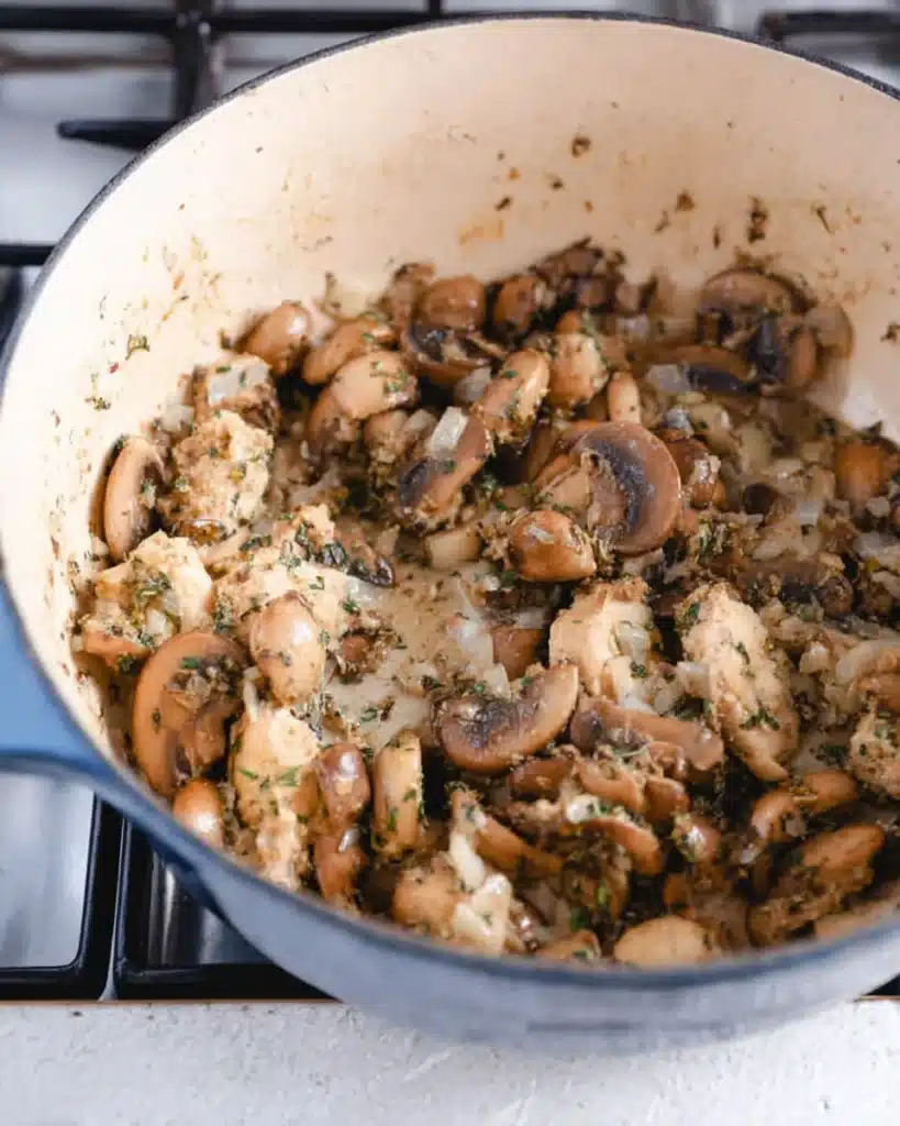 Sautéed mushrooms, onions, and herbs in a Dutch oven for bisque