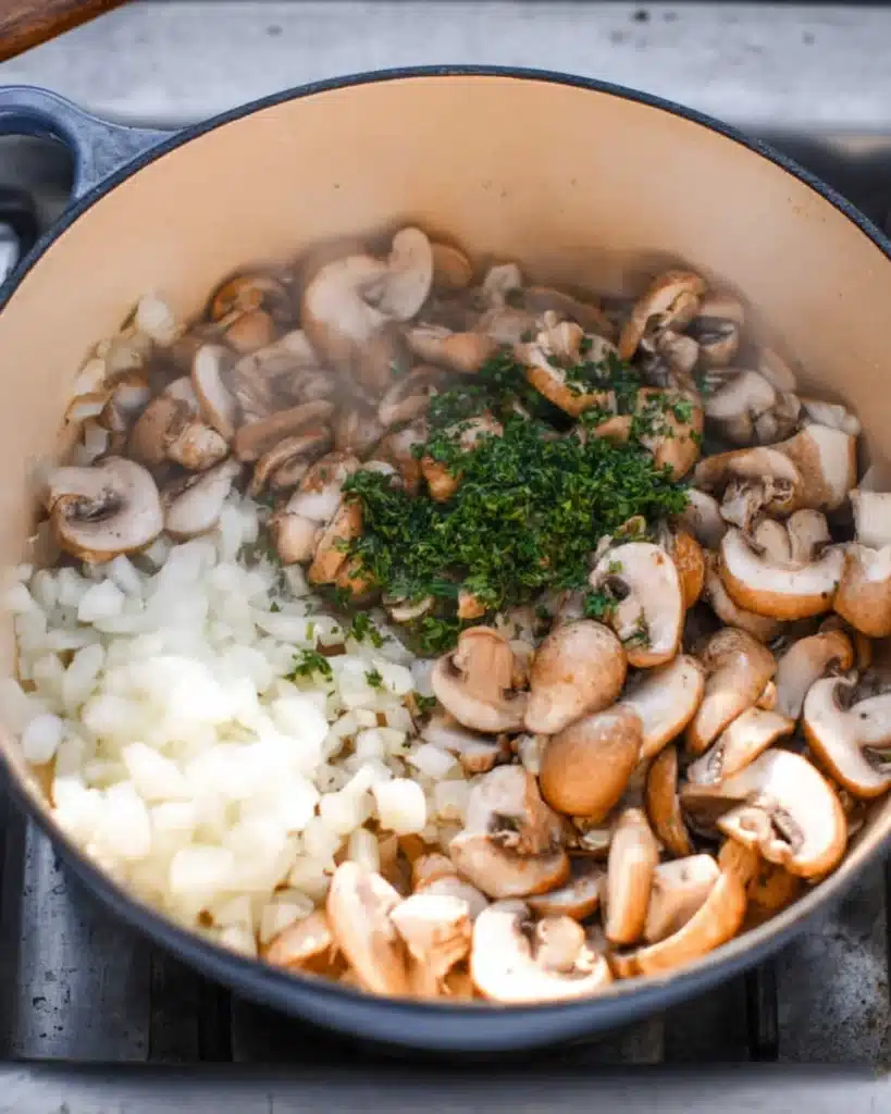 Sautéing mushrooms, onions, and herbs for creamy mushroom bisque