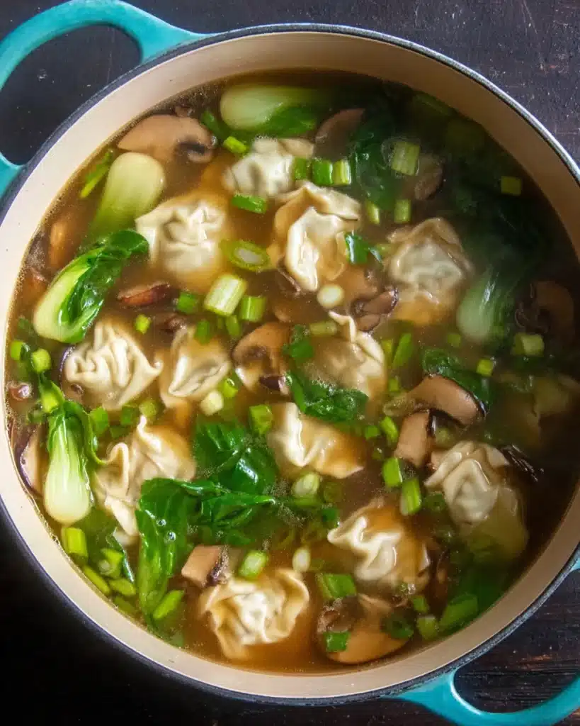 Garnished wonton soup with mushrooms, bok choy, and scallions in broth