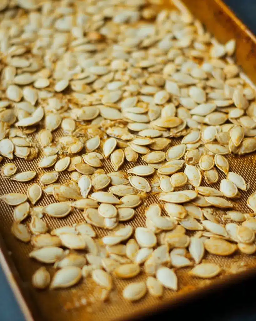 Roasted Pumpkin Seeds Recipe 6 Roasted pumpkin seeds on a baking sheet cooling after baking
