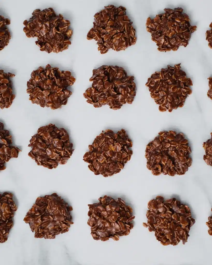 Chocolate no bake cookies cooling on white parchment paper
