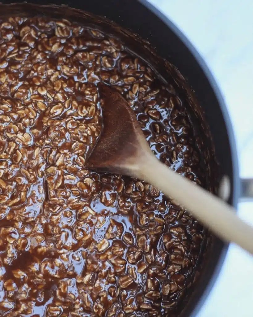 Chocolate oat cookie mixture with wooden spoon in saucepan