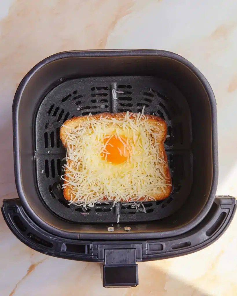 Air fryer egg and cheese toast with shredded mozzarella before cooking