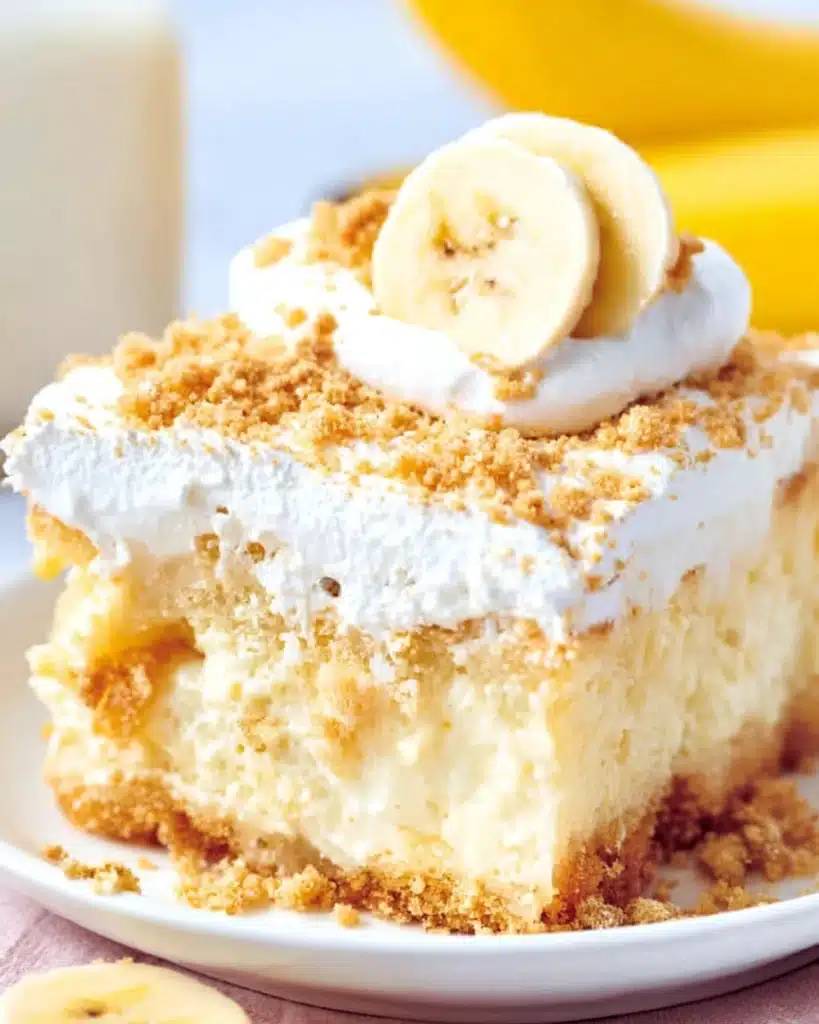 Banana Pudding Poke Cake 1 Slice of banana pudding poke cake with whipped topping and crushed cookies