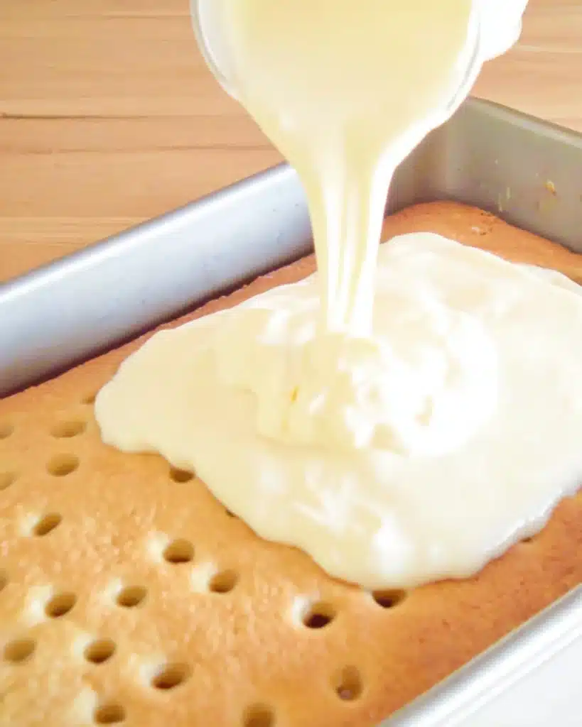 Banana Pudding Poke Cake 2 Pouring banana pudding over poke cake in baking pan