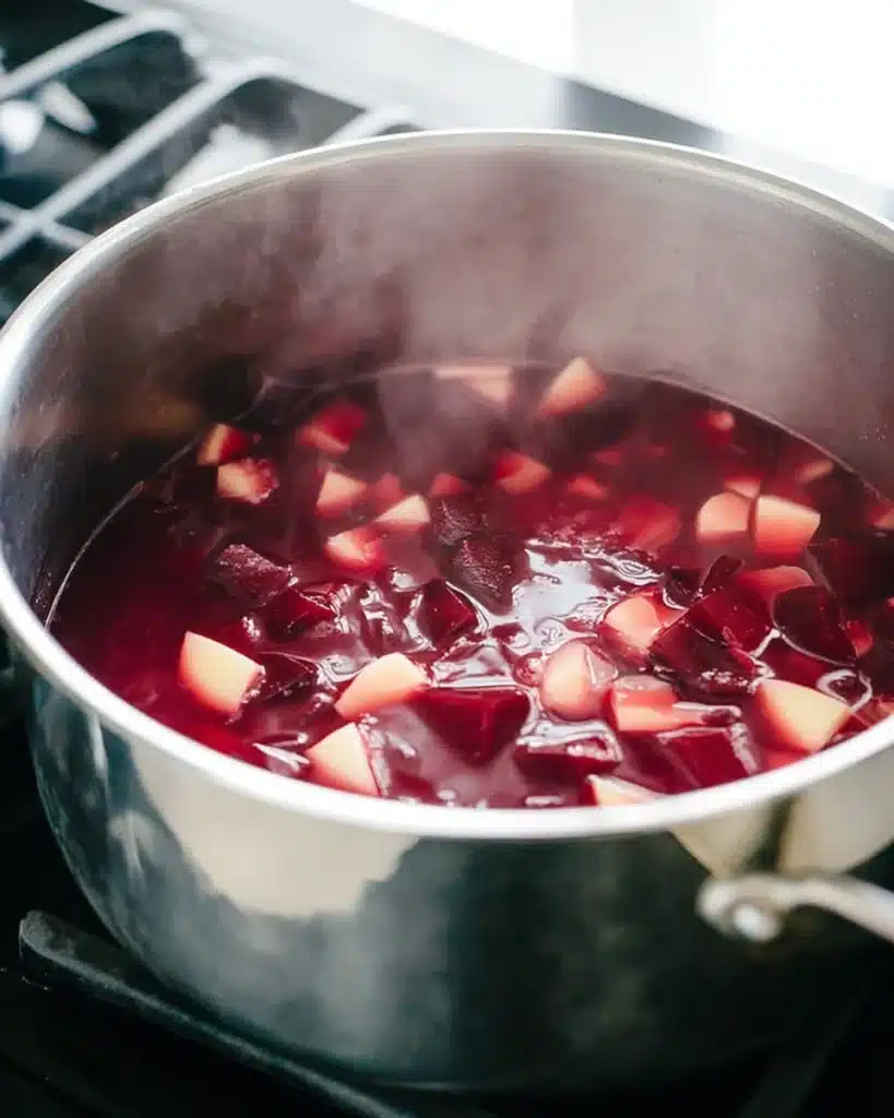 Beet Soup (Smooth and Velvety) 3 Beet and parsnip cubes simmering in a stainless-steel pot for beet soup