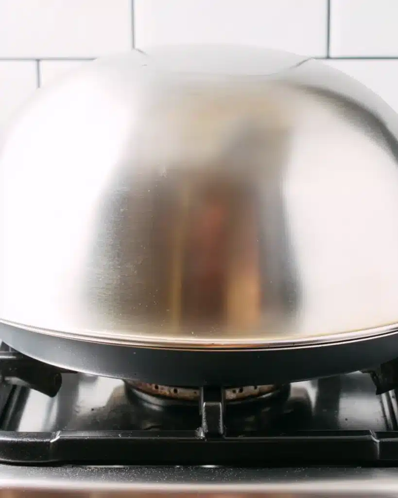 Covering soufflé pancakes with bowl for steaming on stovetop