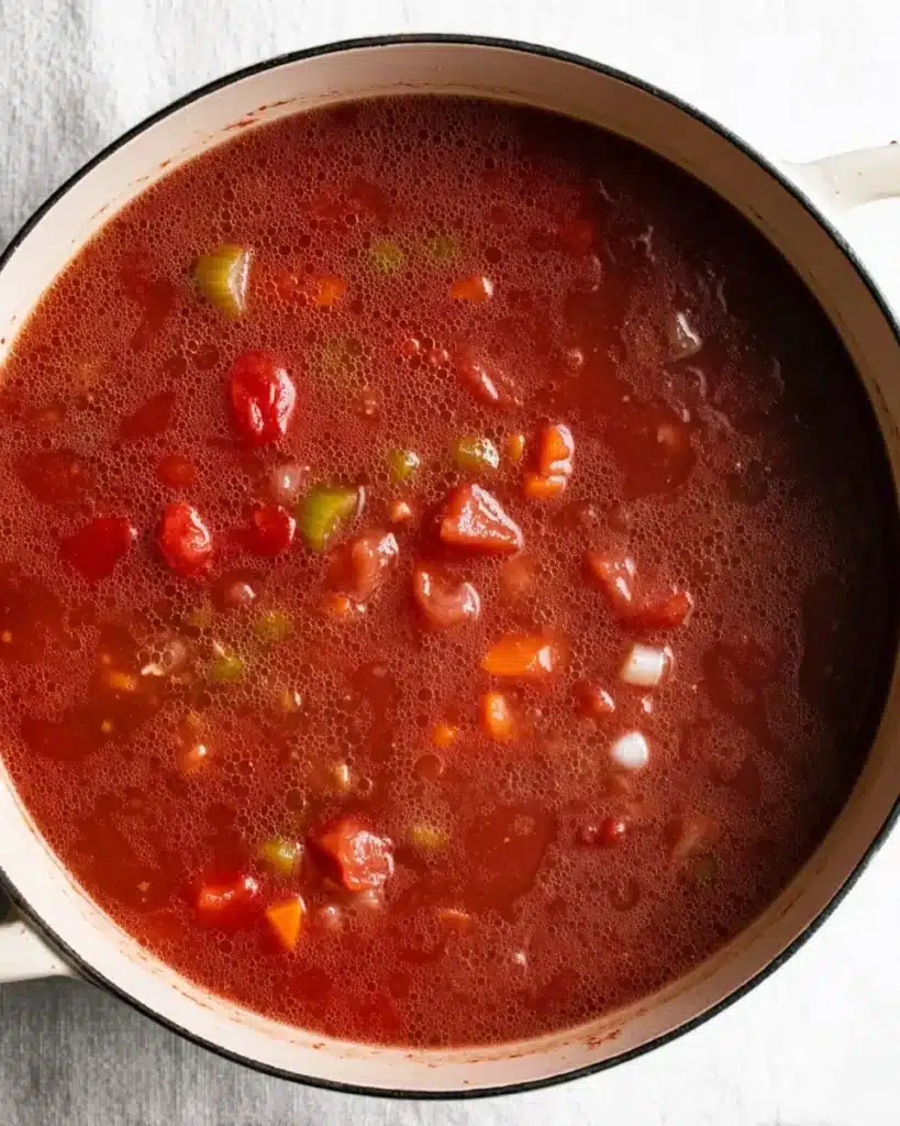 Classic Tomato Soup 3 Tomato soup simmering with onions, celery, and carrots in a Dutch oven