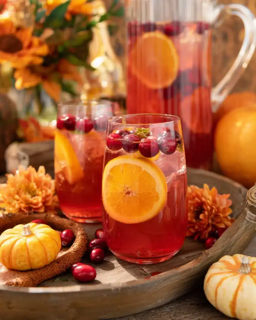 Cranberry Orange Prosecco Punch 1 Cranberry orange prosecco punch with citrus slices and cranberries on a rustic fall table