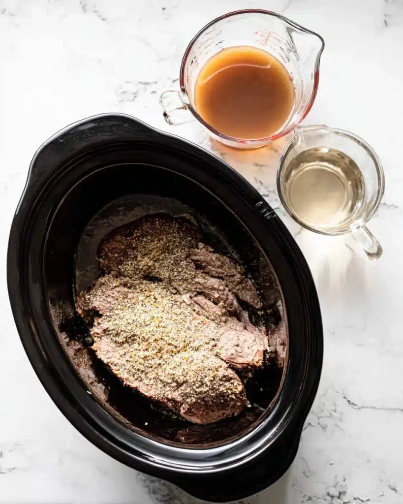Crockpot French Dip Sandwiches 3 Beef chuck roast in slow cooker with onion soup mix and broth ingredients
