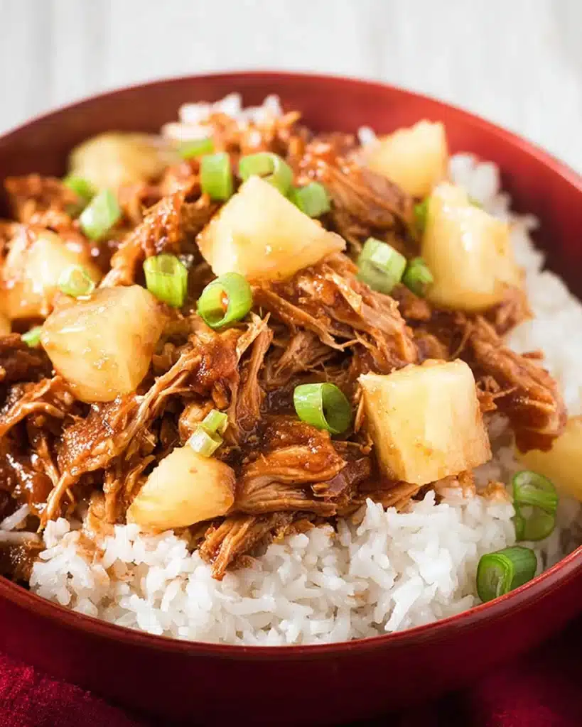 Crockpot Hawaiian BBQ Chicken (Slow Cooker Recipe) 3 Hawaiian BBQ chicken with pineapple and rice in a red bowl