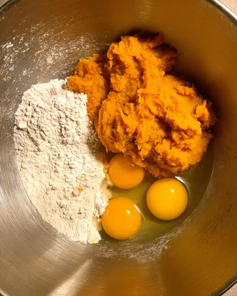 Pumpkin puree, eggs, and cake mix in a bowl for Easy Pumpkin Carrot Cake