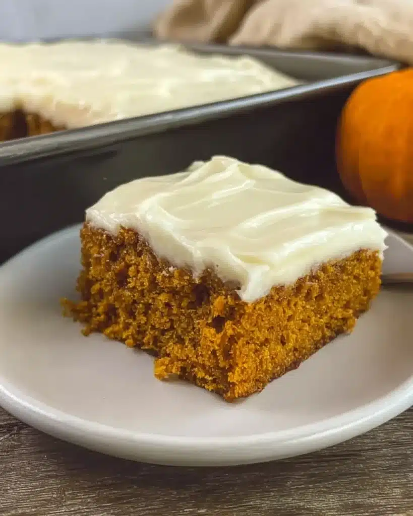 Slice of easy pumpkin carrot cake with cream cheese frosting on a white plate