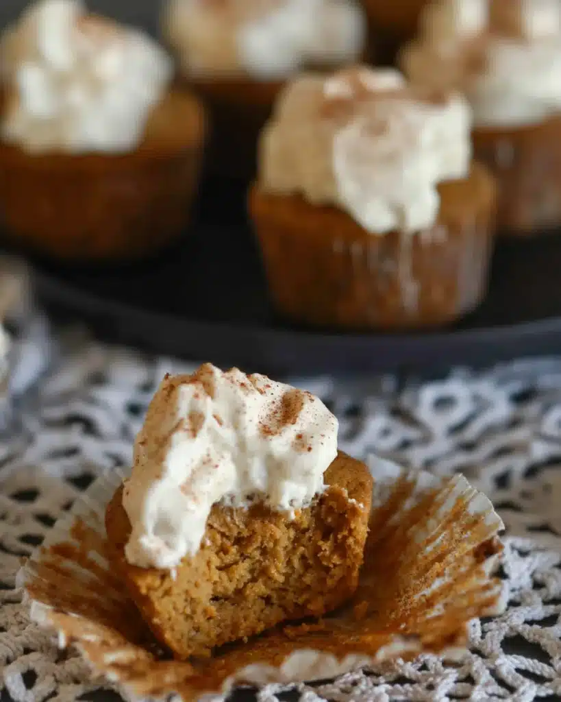 Easy Pumpkin Pie Cupcakes (No Crust Needed!) 3 Pumpkin pie cupcake with a bite taken out topped with whipped cream
