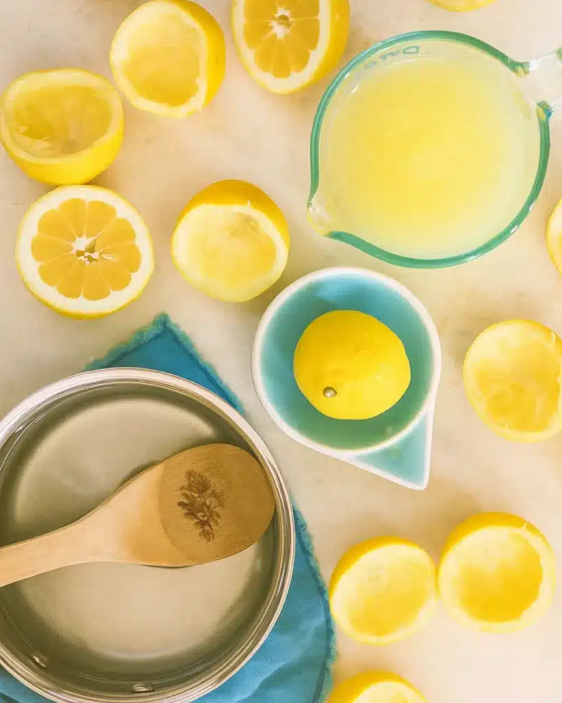The Perfect Homemade Lemonade 2 Fresh lemons and ingredients for homemade lemonade on a marble surface