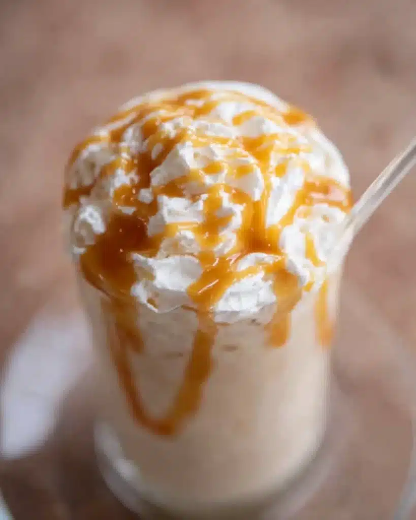 Caramel frappe topped with whipped cream and caramel drizzle