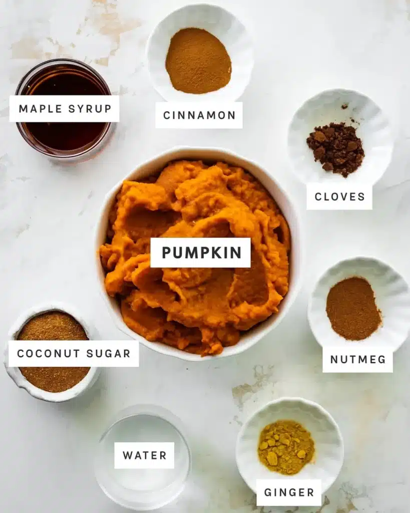 Pumpkin butter ingredients arranged in labeled bowls on light surface