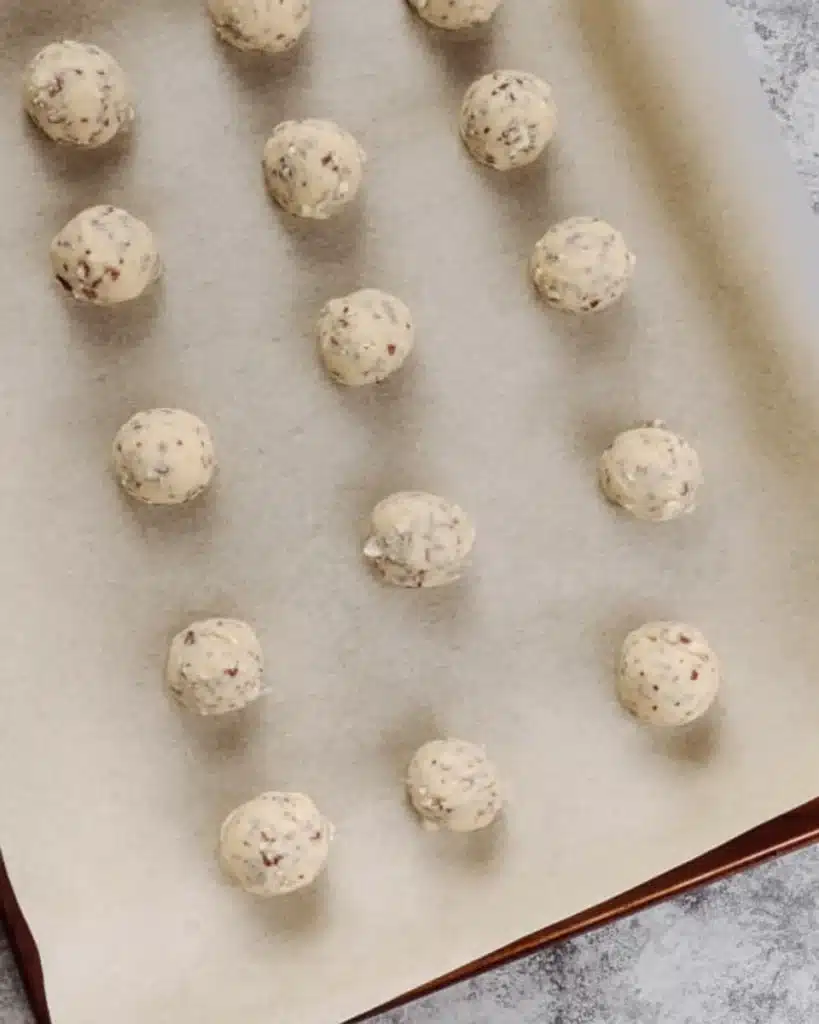 Russian Tea Cakes 4 Unbaked Russian Tea Cakes dough balls on parchment-lined baking sheet