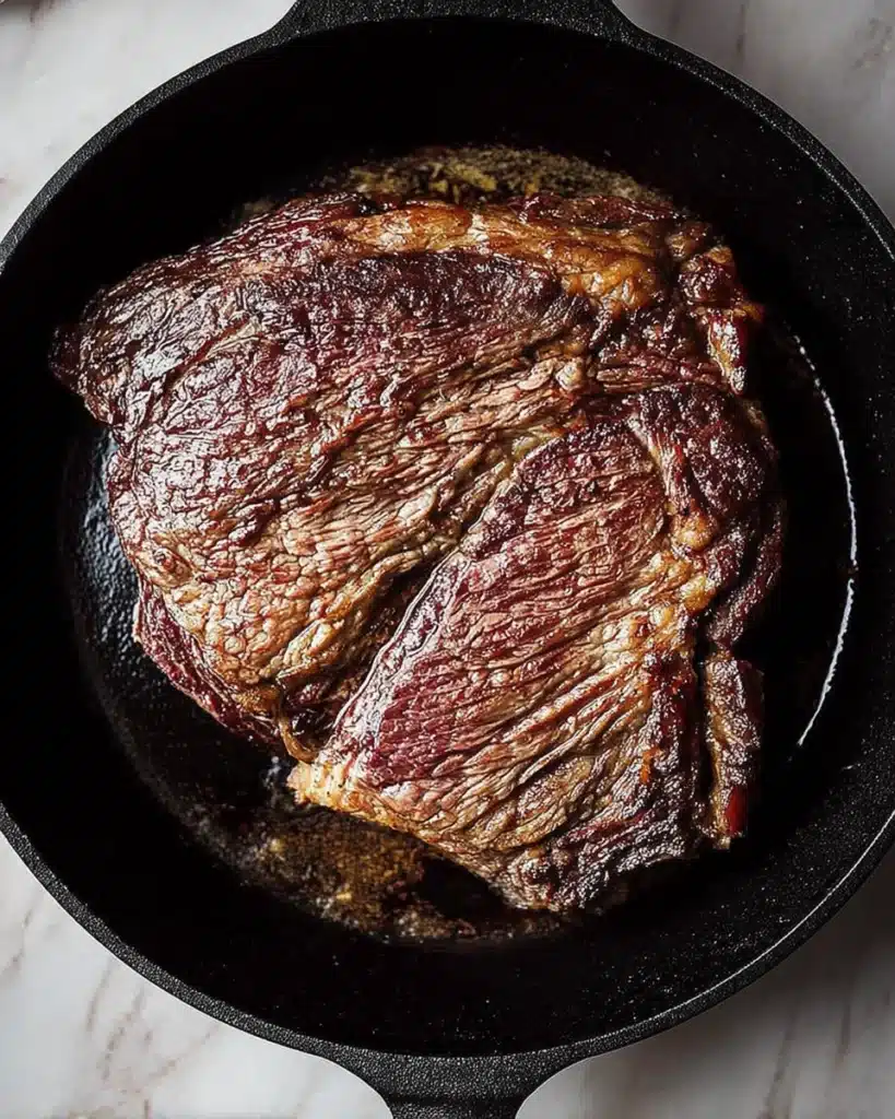 Slow Cooker Pot Roast (Tender, Flavorful & Easy) 2 Searing beef chuck roast in cast-iron skillet for slow cooker pot roast