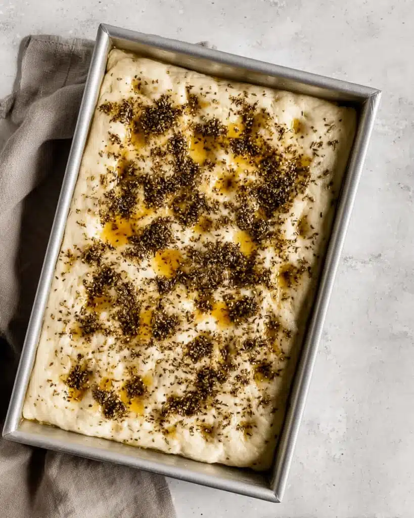 Easy No-Knead Za’atar Focaccia Bread (Appetizer Recipes) 3 Focaccia dough topped with za’atar and olive oil in a baking pan