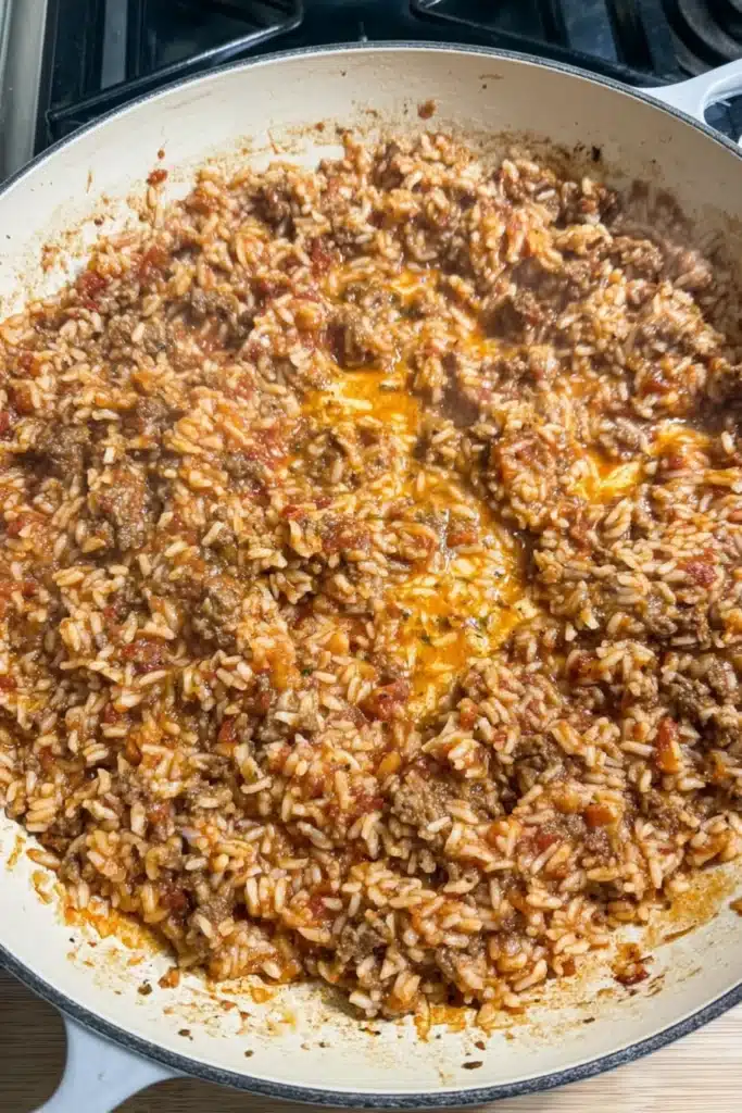 Bacon Cheeseburger Rice Skillet 2 Skillet filled with cheesy bacon cheeseburger rice mixture cooking on stove