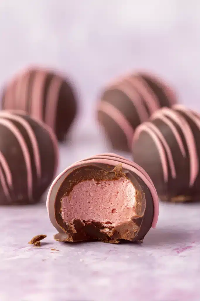 Chocolate Raspberry Truffles 3 Bitten chocolate raspberry truffle showing pink creamy filling