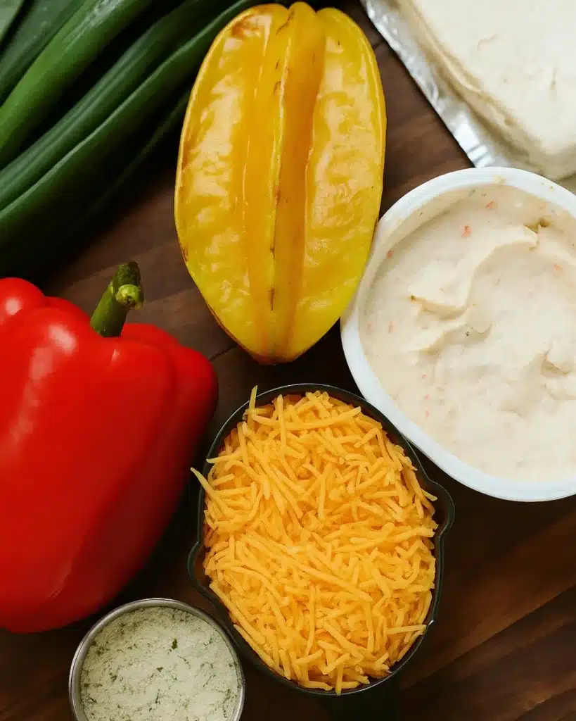 Christmas Tree Cheeseball ingredients including cream cheese, cheddar, and red pepper