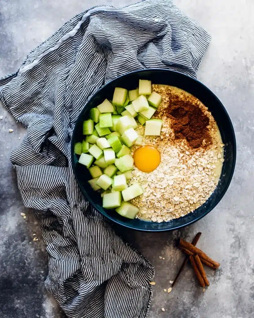 Cinnamon apple oatmeal muffin batter ingredients in a bowl before mixing